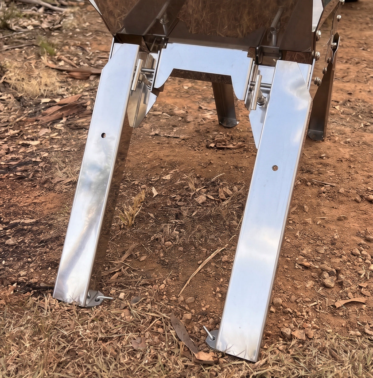 Tyre Fire stainless steel fire pit extension legs pegged into the ground at a campsite