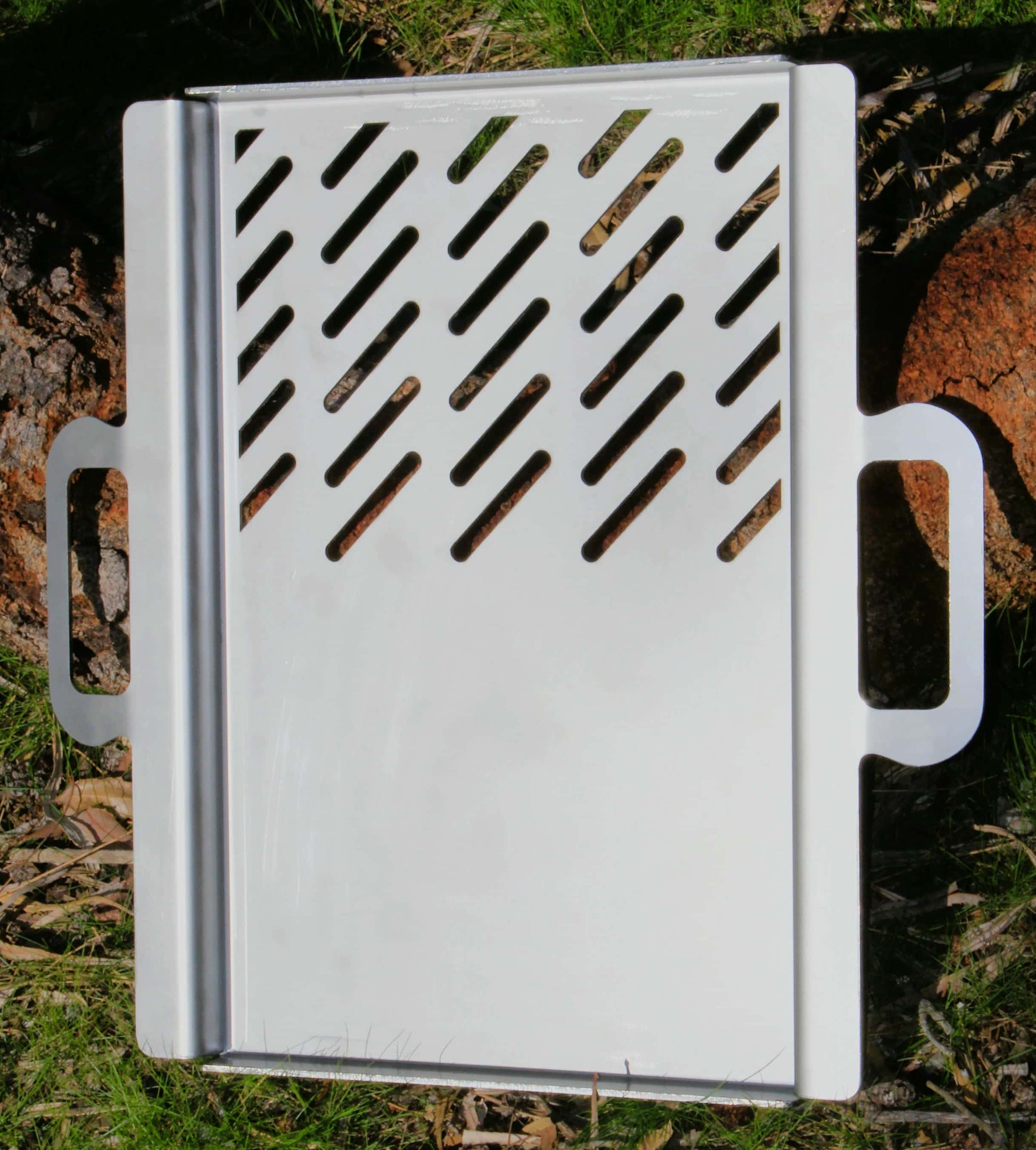 Stainless steel grill plate hot plate with handles on a natural background