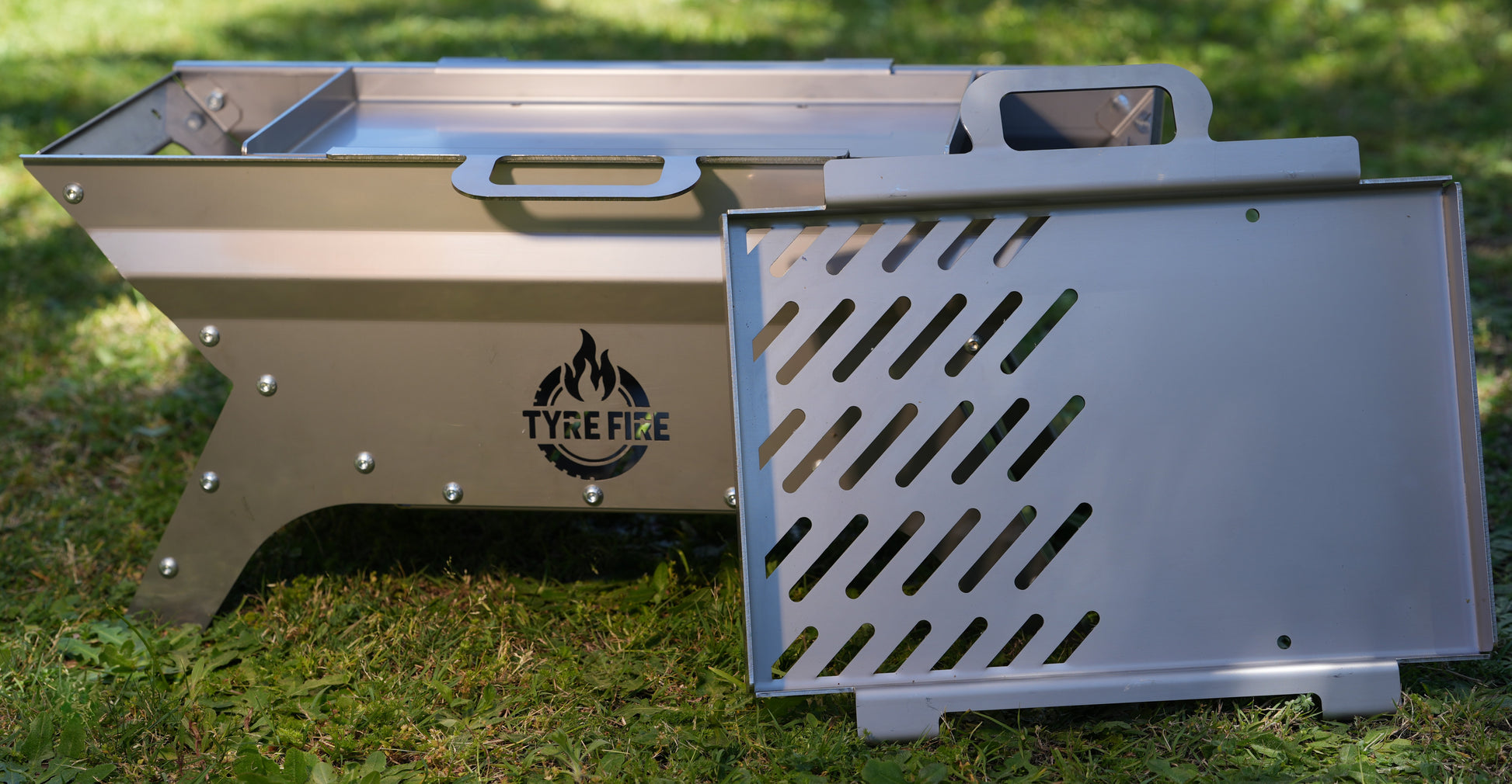 Precision-engineered Tyre Fire® portable fire pit with 2-in-1 BBQ grill plate showing the modular M8 bolted anti-warp chassis