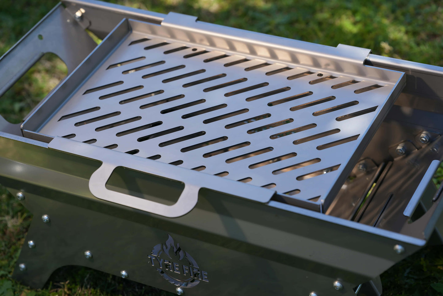 Stainless steel grilling plate sitting on top of the Tyre Fire barbecue built for spare wheels
